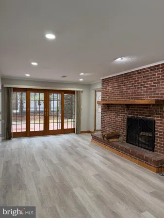 a view of an empty room with a fireplace and a window