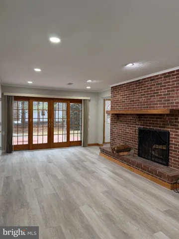 a view of an empty room with a fireplace and a window