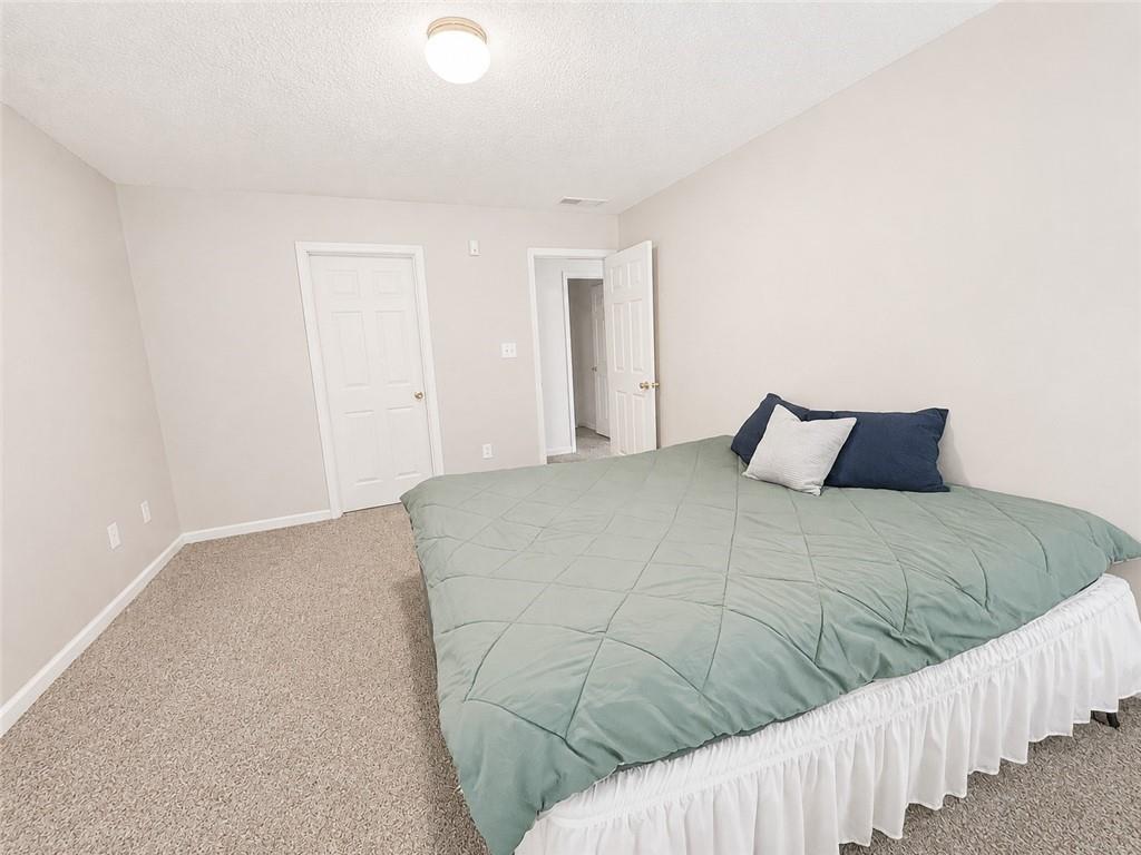 6936 Red Bone Way Stonecrest, GA 30038 - Photo 11 of 17 a bedroom with a bed and wooden floor