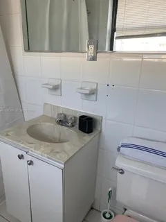 a bathroom with a granite countertop toilet sink and mirror