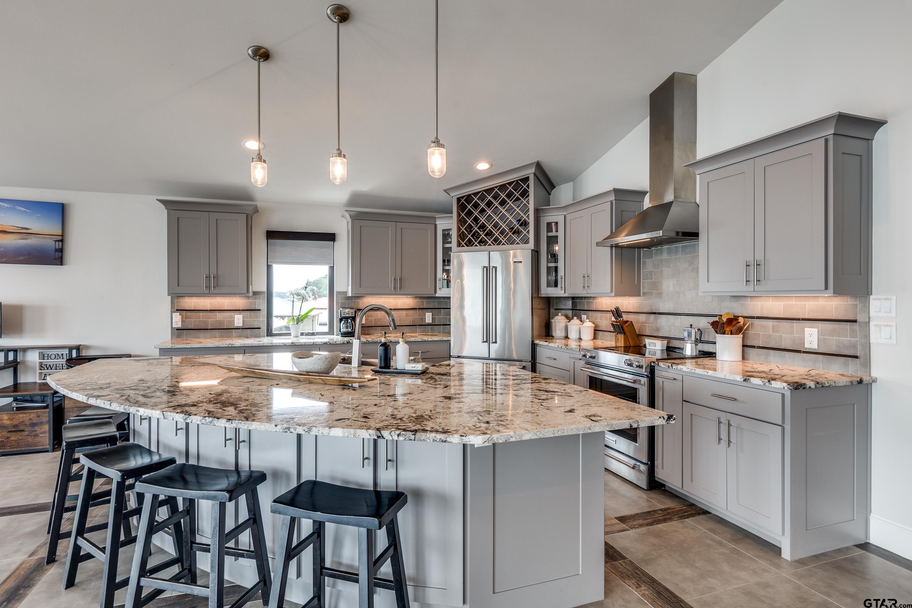 16822 Perry Street Tyler, TX 75707 - Photo 29 of 45 a kitchen with kitchen island granite countertop a table chairs sink and cabinets