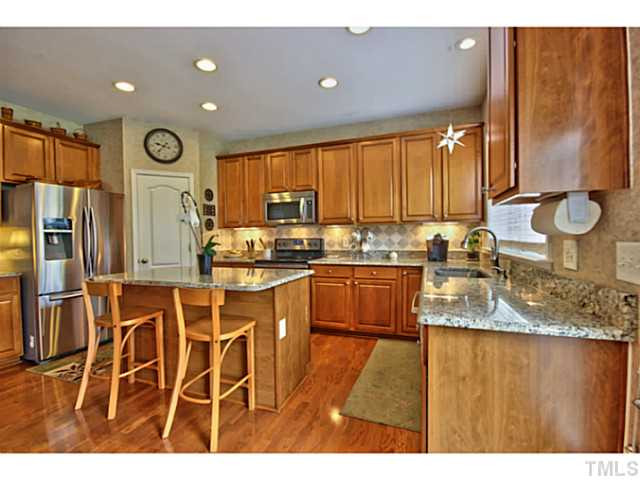 7620 Derek Drive Raleigh, NC 27613 - Photo 9 of 25 It also has an island, pantry, tons of cabinets and a built in desk. Kitchen