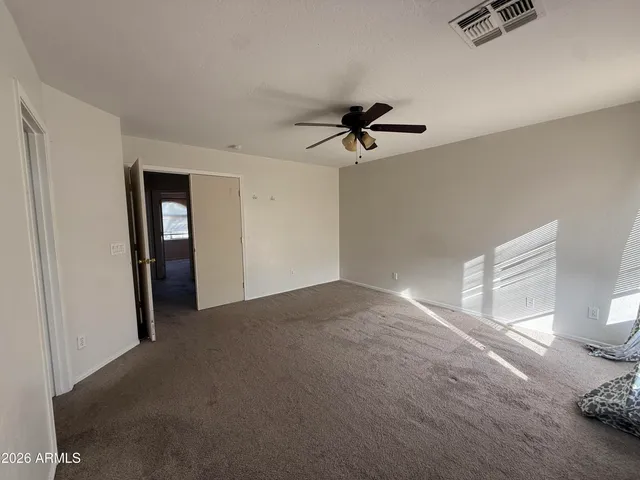 a view of a livingroom with a chandelier fan and wooden floor
