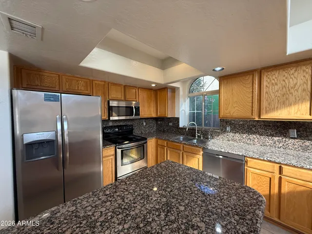 a kitchen with stainless steel appliances granite countertop a refrigerator and a sink
