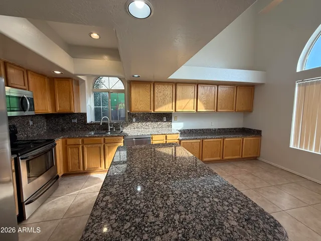 a kitchen with stainless steel appliances granite countertop a stove a sink and a microwave