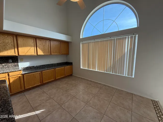 a kitchen with granite countertop a sink a stove and cabinets