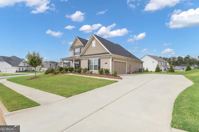 a front view of a house with a garden and yard