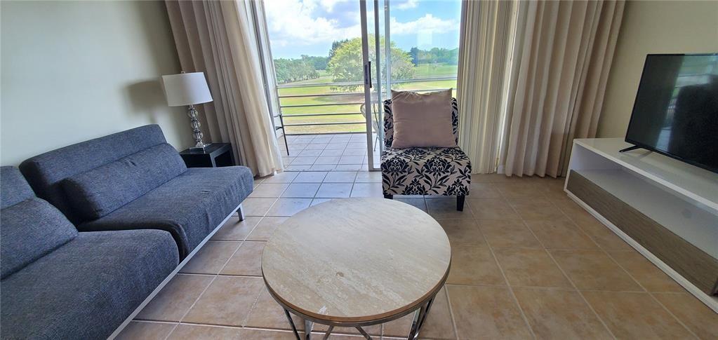 5100 Southwest 90th Avenue, Unit 406 Cooper City, FL 33328 - Photo 3 of 25 a living room with furniture and a large window