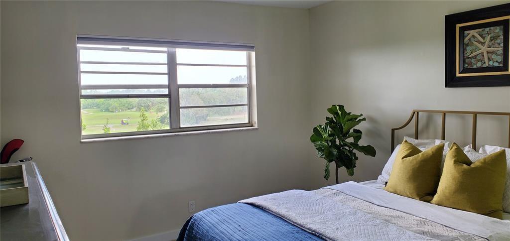 5100 Southwest 90th Avenue, Unit 406 Cooper City, FL 33328 - Photo 6 of 25 a bedroom with a bed and a potted plant