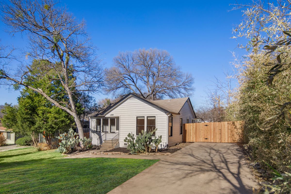 View of front of home featuring a gate and driveway