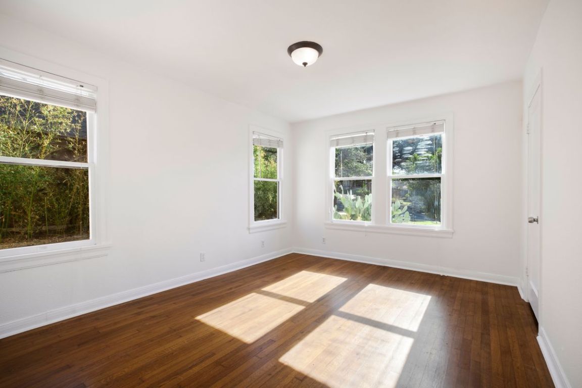 1704 Northwood Road Austin, TX 78703 - Photo 13 of 22 an empty room with wooden floor and windows
