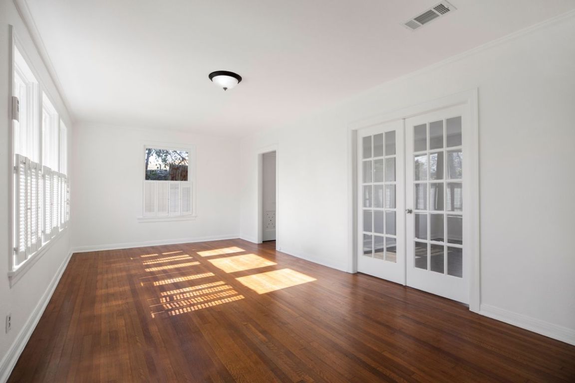 1704 Northwood Road Austin, TX 78703 - Photo 3 of 22 a view of an empty room with wooden floor and a window