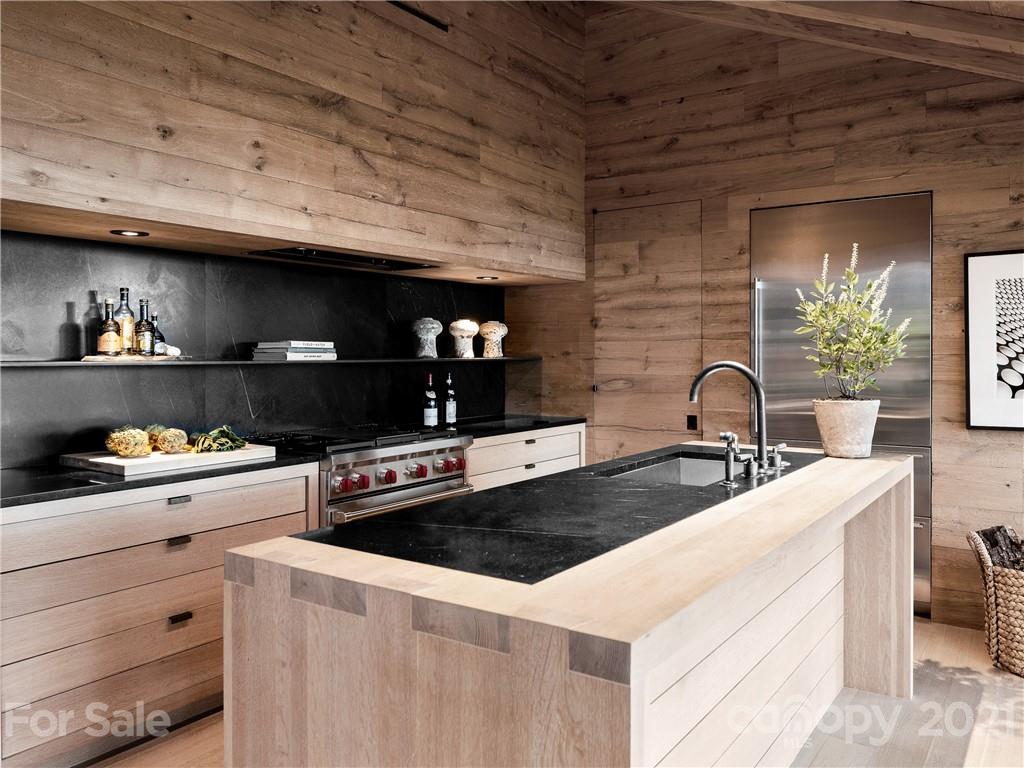 318 Summer Haven Lane Saluda, NC 28773 - Photo 9 of 40 a kitchen with granite countertop a stove and a wooden cabinets