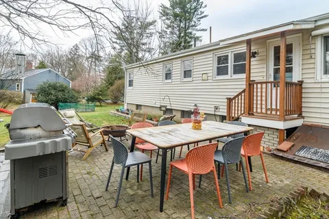a backyard of a house with table and chairs