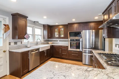 a large kitchen with cabinets a sink and stainless steel appliances