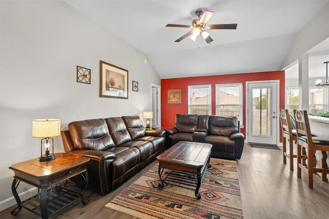 a living room with furniture a fireplace and a chandelier
