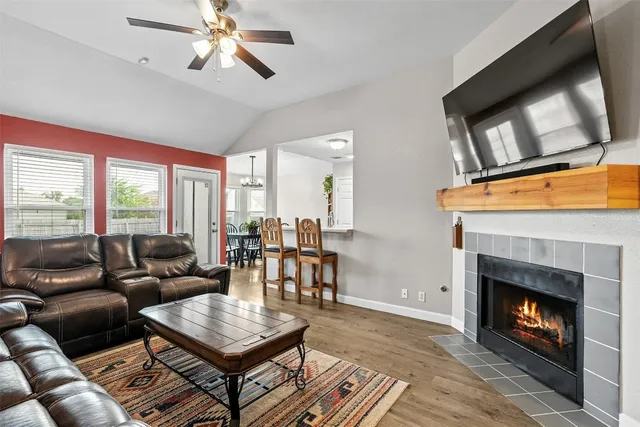 a living room with furniture a flat screen tv and a fireplace