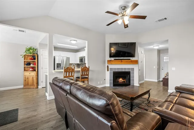 a living room with furniture a fireplace and a flat screen tv