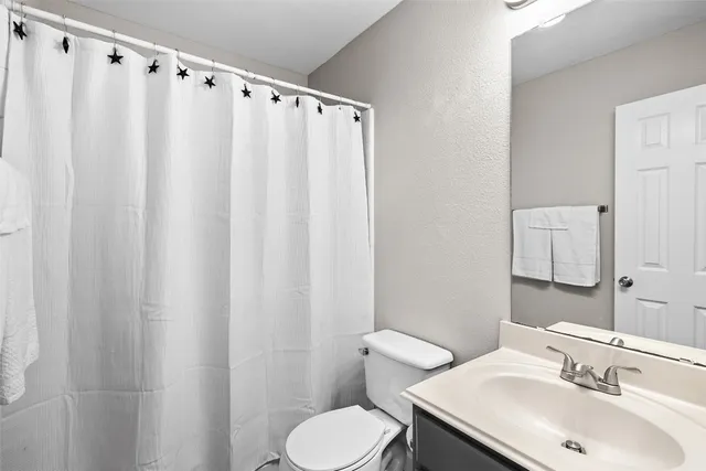 a bathroom with a sink mirror and toilet