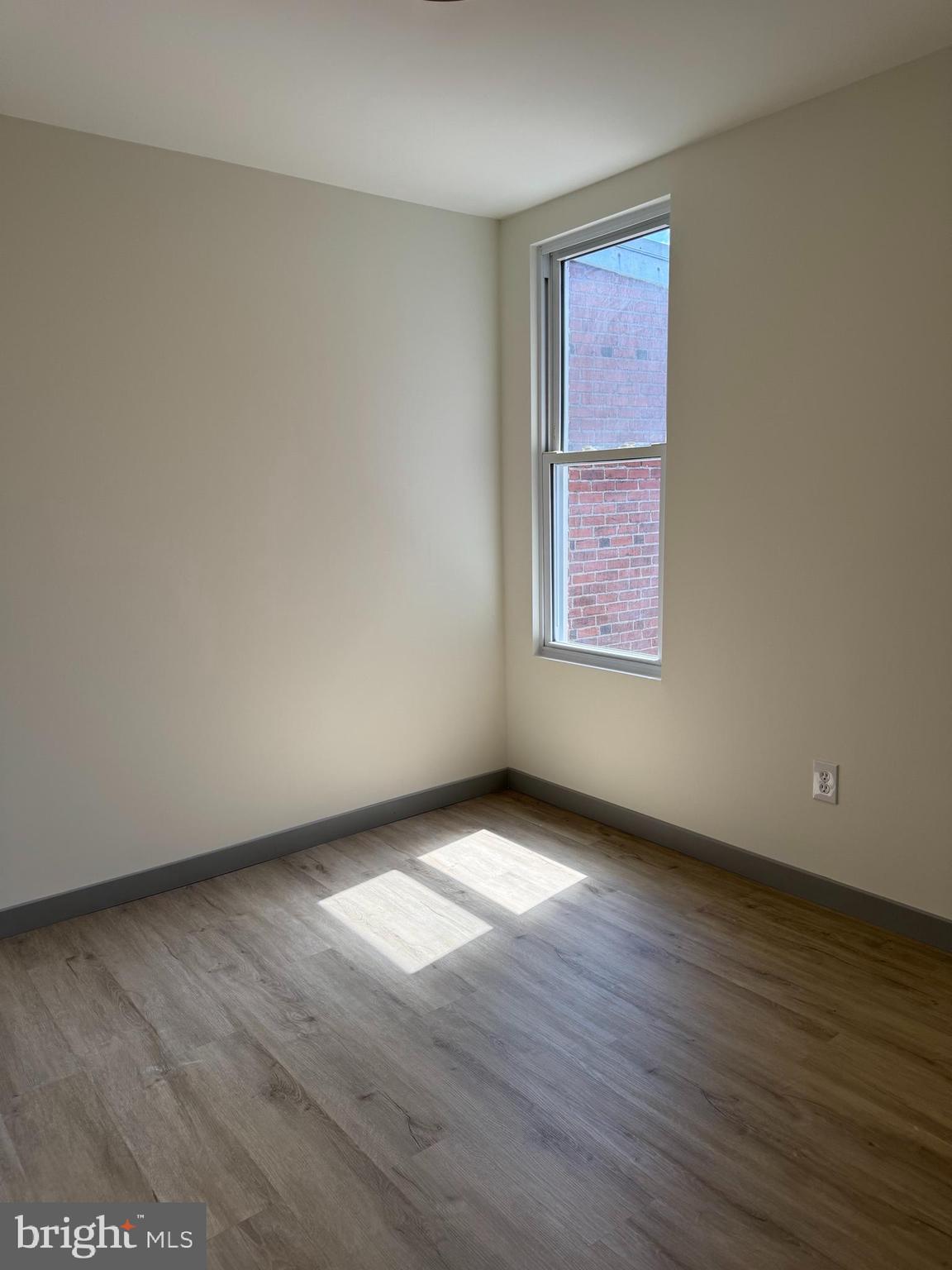 7816 Temple Road Philadelphia, PA 19150 - Photo 9 of 24 a view of an empty room with wooden floor and a window