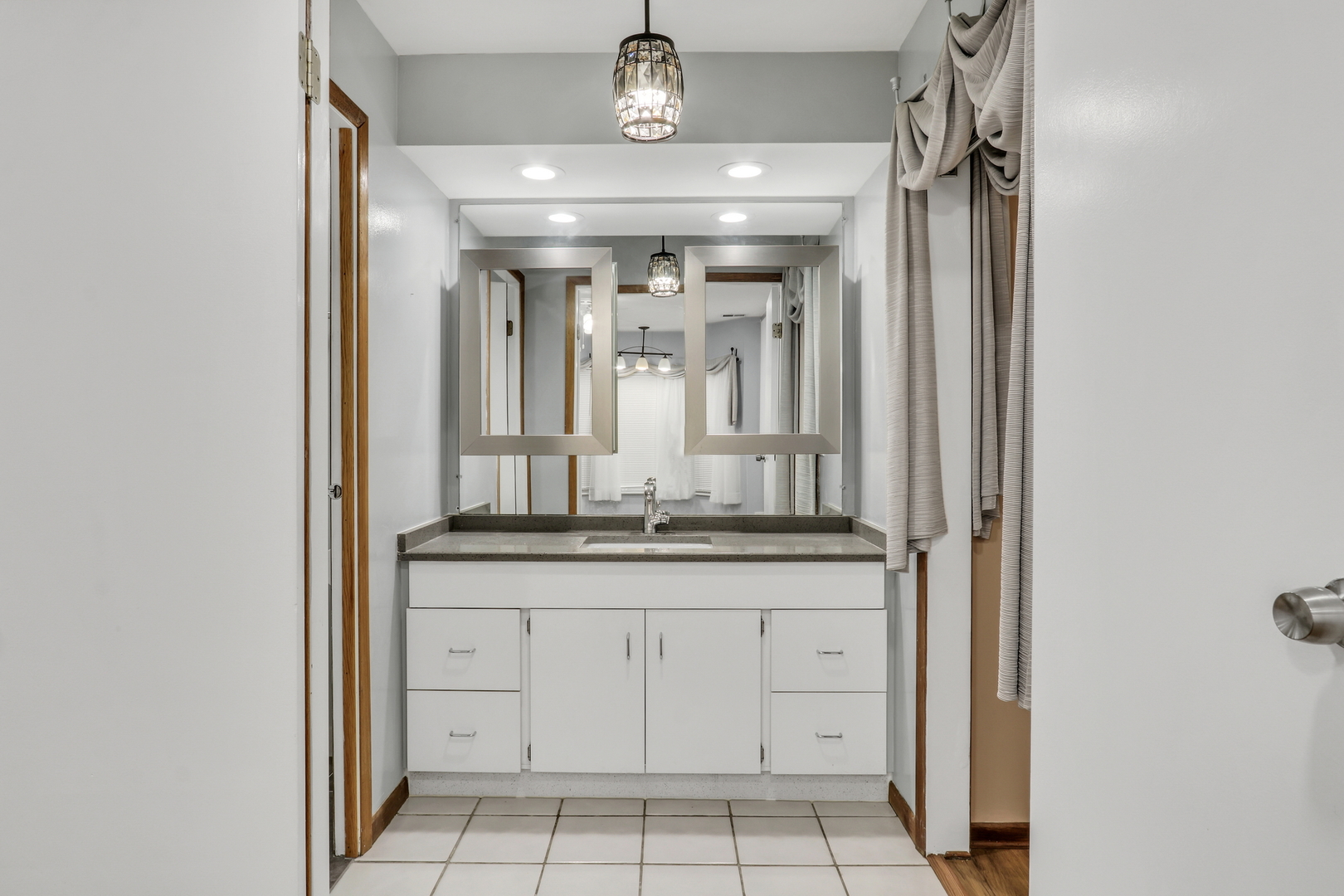 8620 Waukegan Road, Unit 107 Morton Grove, IL 60053 - Photo 12 of 18 a bathroom with a granite countertop sink a mirror and a vanity