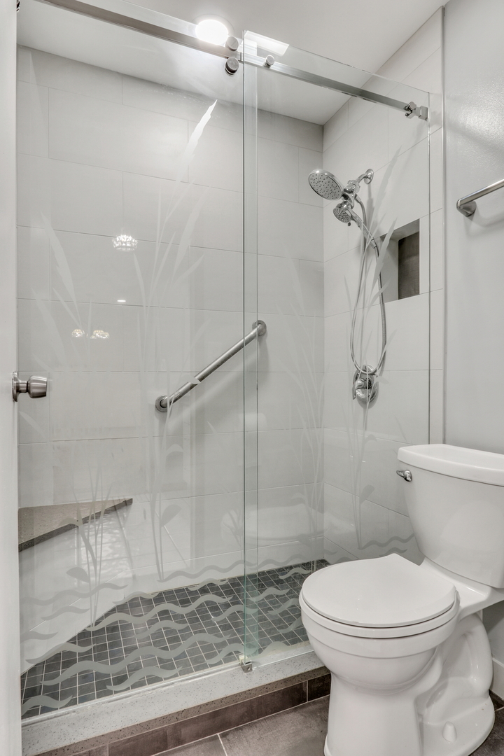 8620 Waukegan Road, Unit 107 Morton Grove, IL 60053 - Photo 14 of 18 a bathroom with a toilet and a shower