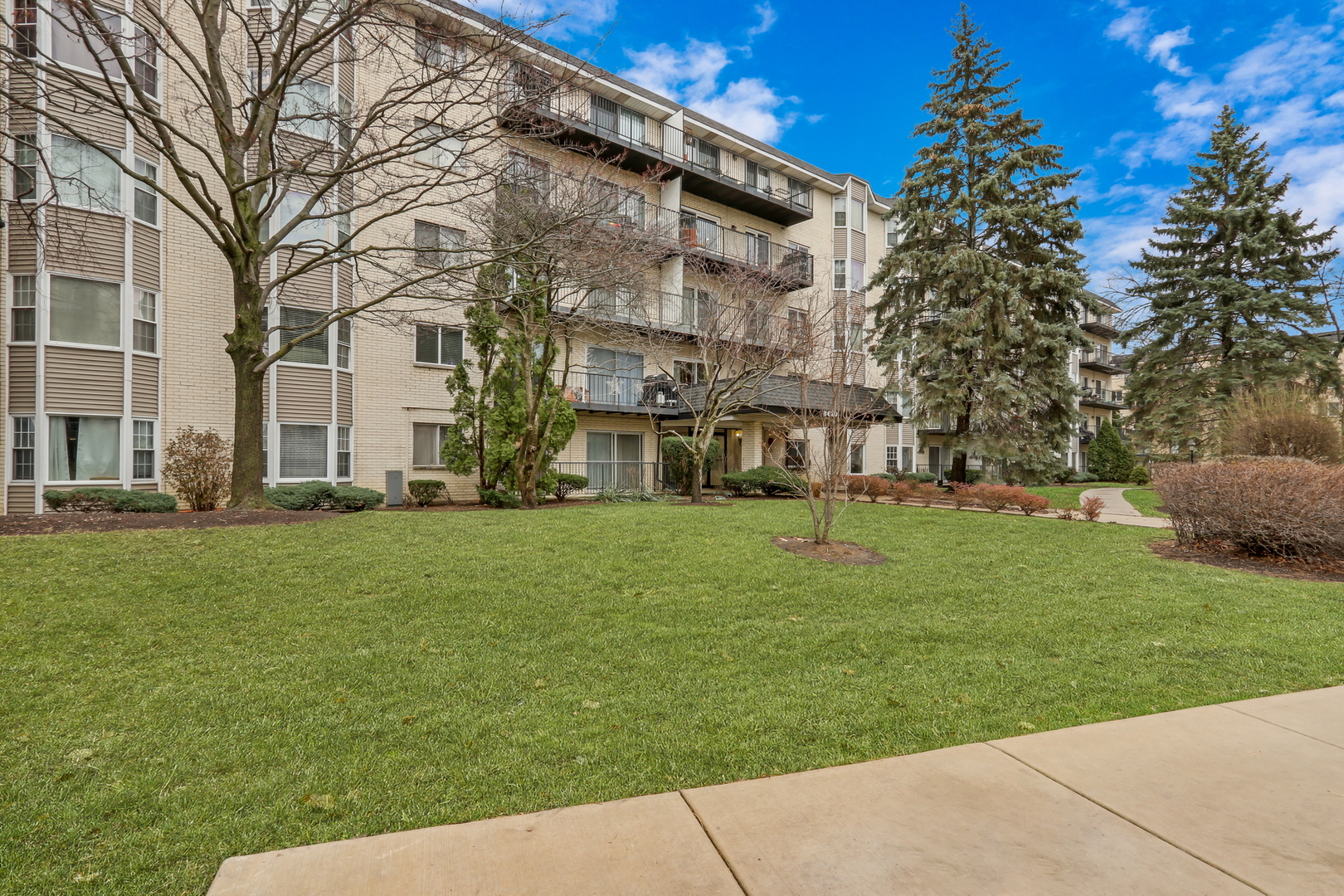 8620 Waukegan Road, Unit 107 Morton Grove, IL 60053 - Photo 16 of 18 a view of a building with a yard