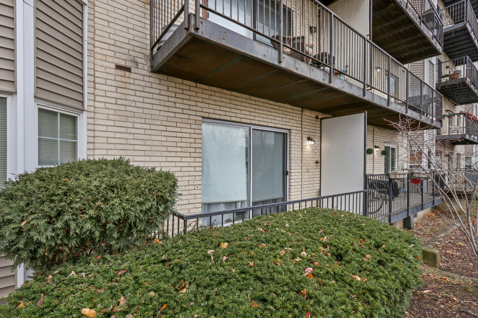 8620 Waukegan Road, Unit 107 Morton Grove, IL 60053 - Photo 18 of 18 a view of a house with a small yard and wooden floor and fence