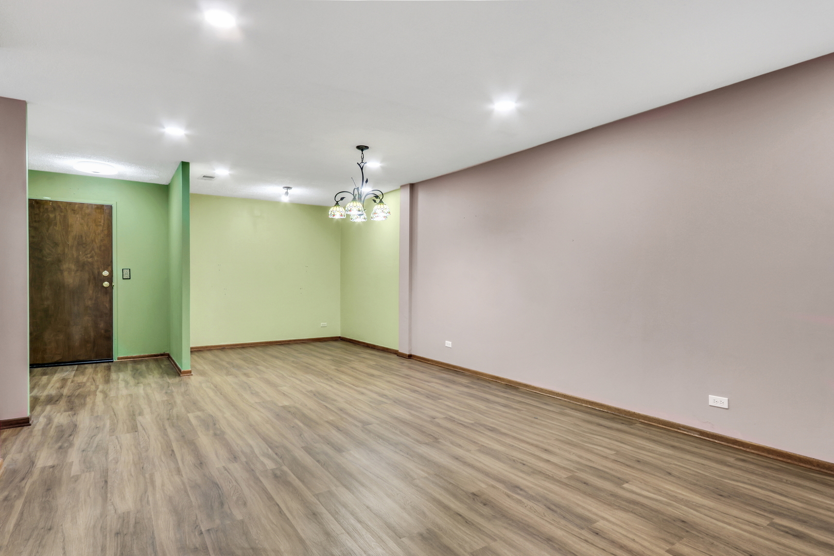 8620 Waukegan Road, Unit 107 Morton Grove, IL 60053 - Photo 4 of 18 an empty room with wooden floor and a ceiling fan