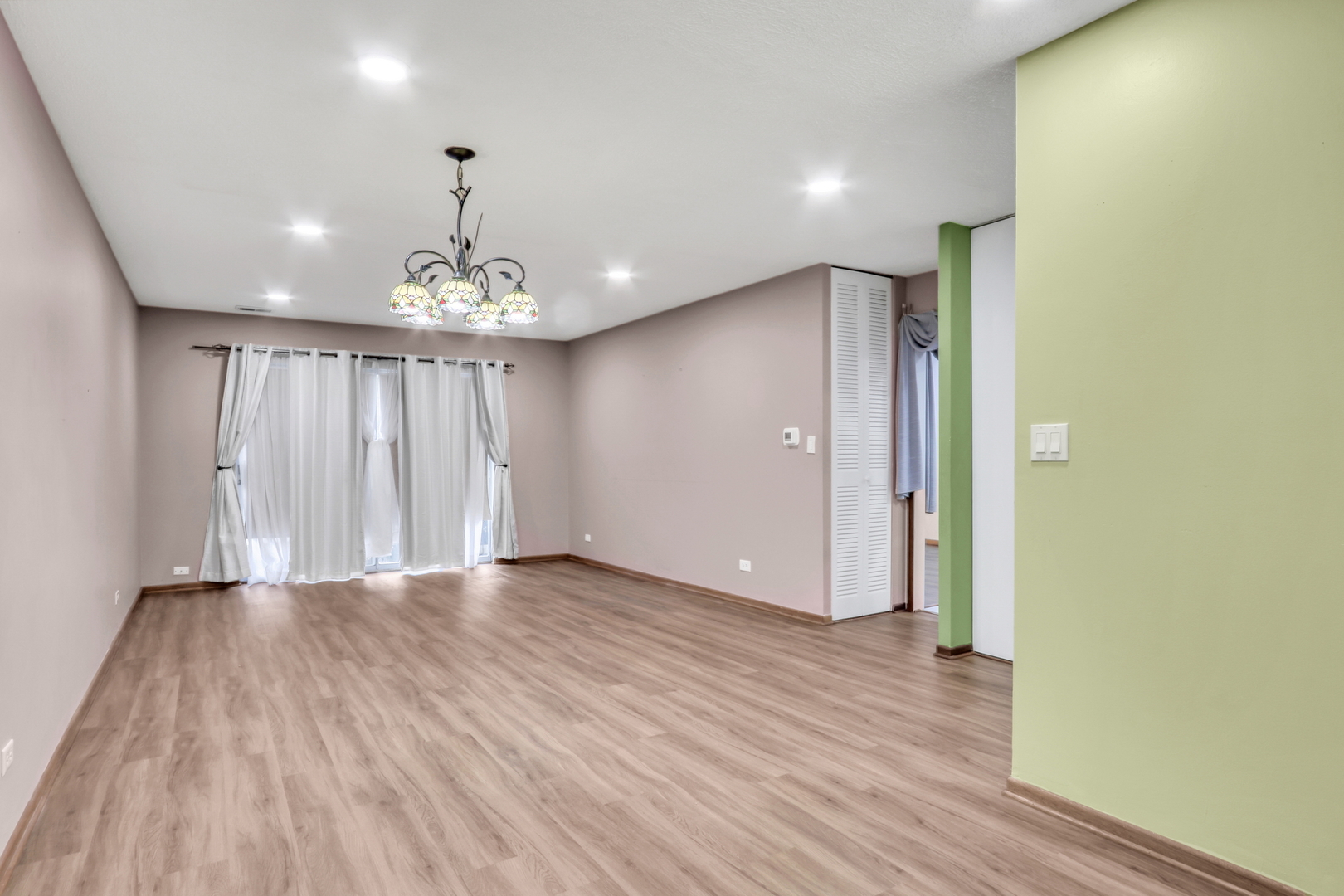 8620 Waukegan Road, Unit 107 Morton Grove, IL 60053 - Photo 6 of 18 wooden floor in an empty room with a window