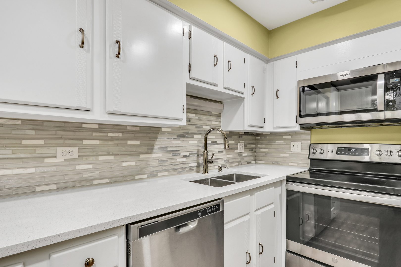 8620 Waukegan Road, Unit 107 Morton Grove, IL 60053 - Photo 8 of 18 a kitchen with stainless steel appliances a sink stove and microwave