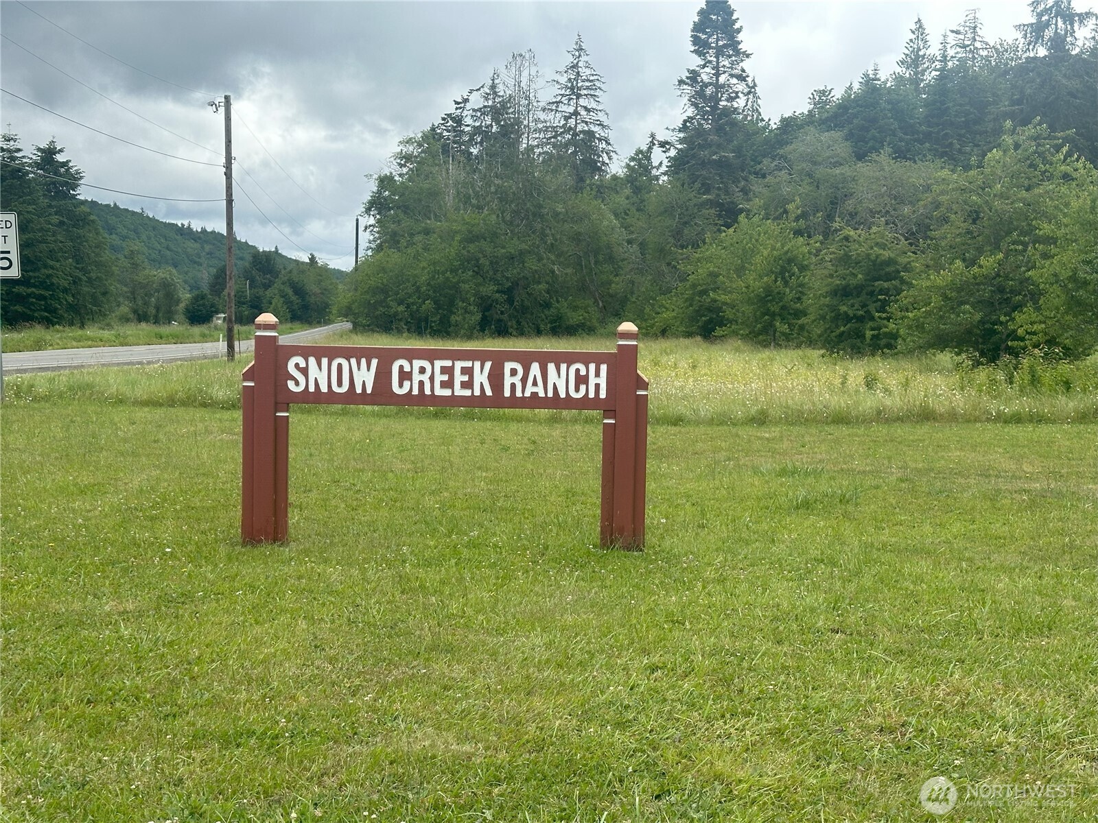 0 Skidder Hill Road Quilcene, WA 98376 - Photo 7 of 13 a sign that is sitting in the grass next to a yard