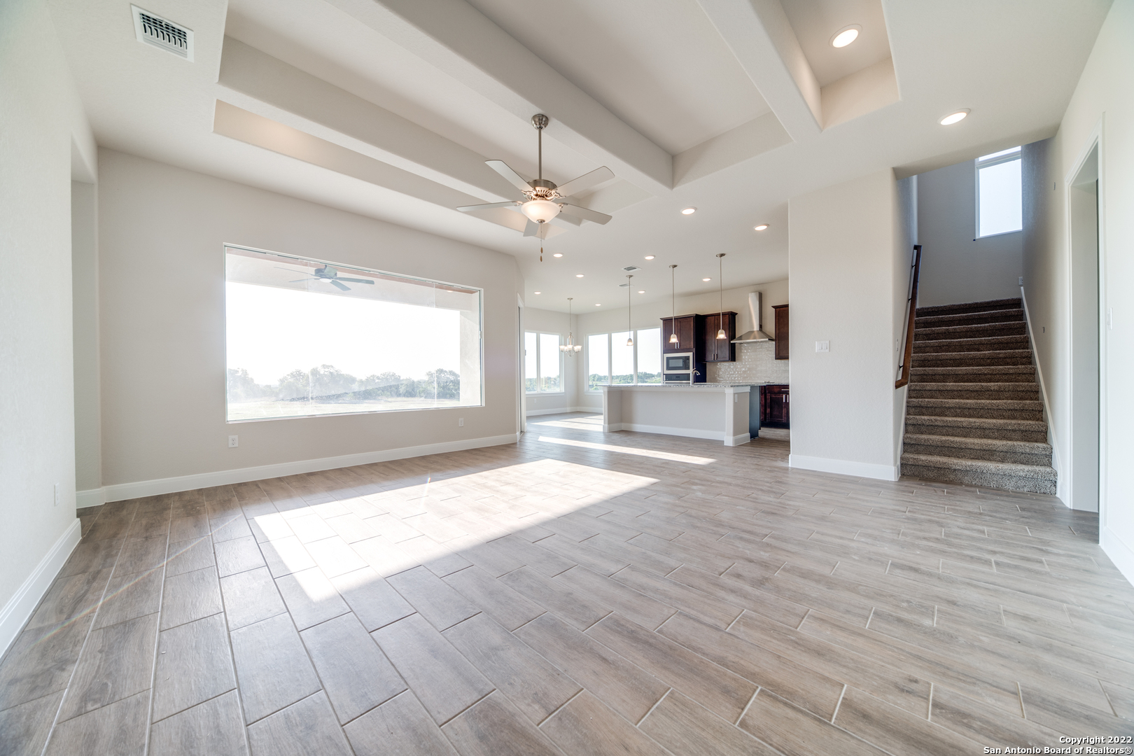 238 Peter Kleid Loop Blanco, TX 78606 - Photo 13 of 25 an empty room with wooden floor kitchen view and windows