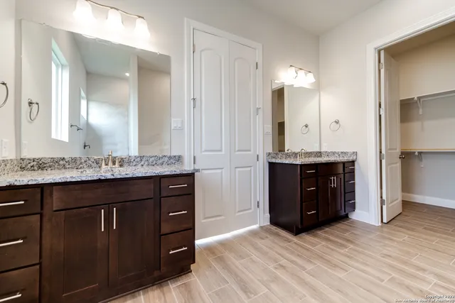 a bathroom with a granite countertop sink and a mirror