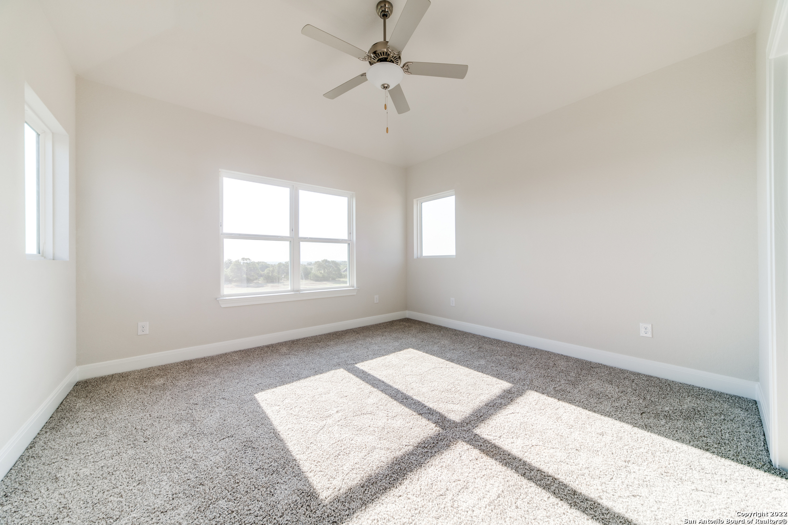238 Peter Kleid Loop Blanco, TX 78606 - Photo 20 of 25 an empty room with windows and ceiling fan