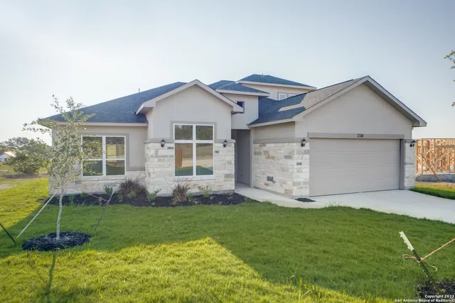 a front view of a house with a garden and yard