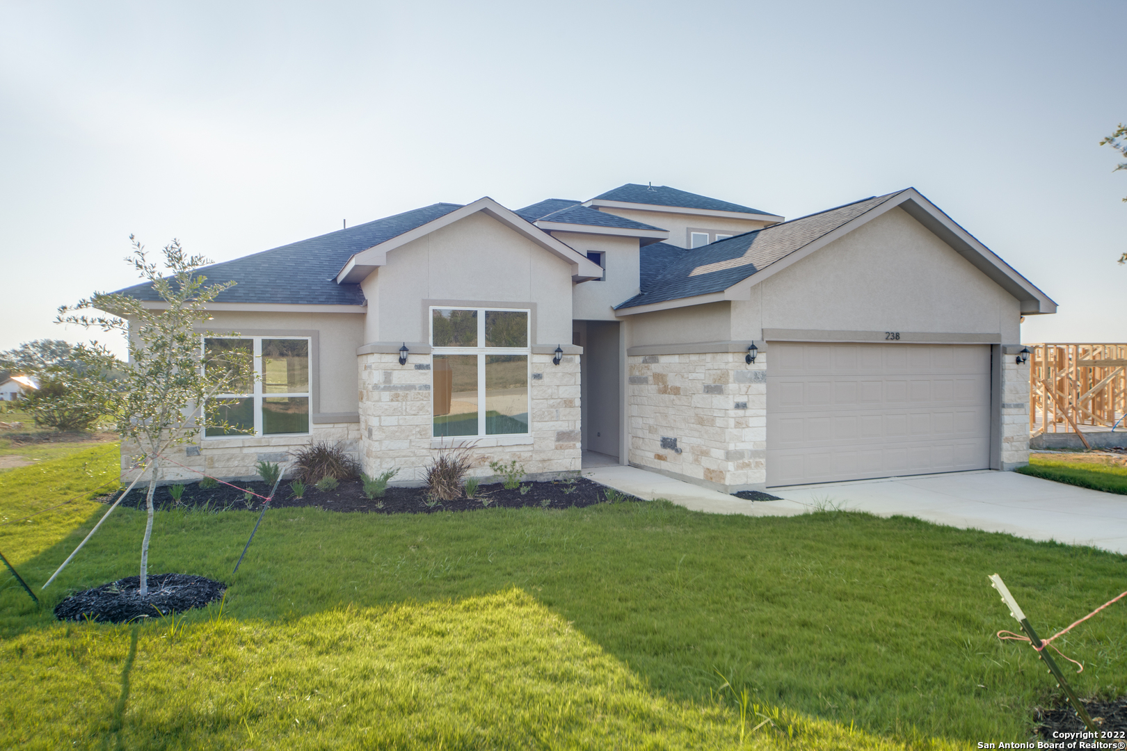 238 Peter Kleid Loop Blanco, TX 78606 - Photo 2 of 25 a front view of a house with a garden and yard