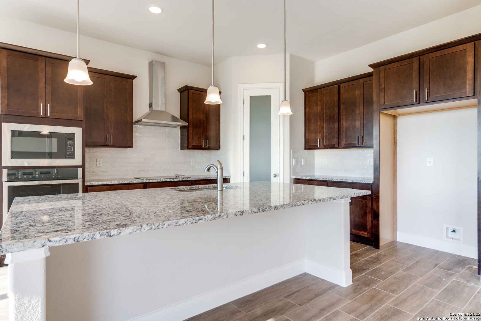 238 Peter Kleid Loop Blanco, TX 78606 - Photo 5 of 25 a kitchen with stainless steel appliances granite countertop a refrigerator a stove and a sink with wooden floor