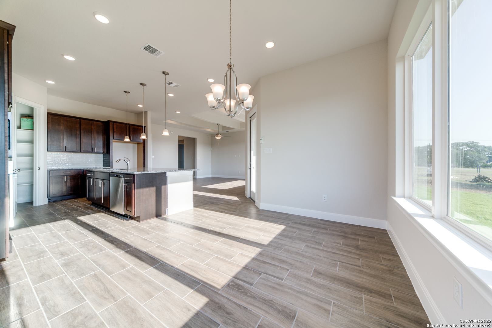 238 Peter Kleid Loop Blanco, TX 78606 - Photo 7 of 25 a large kitchen with stainless steel appliances kitchen island granite countertop a sink and cabinets