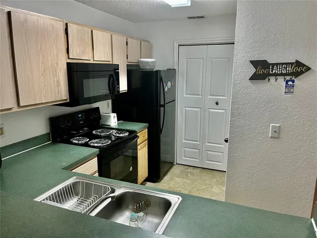 a kitchen with granite countertop a stove and a refrigerator