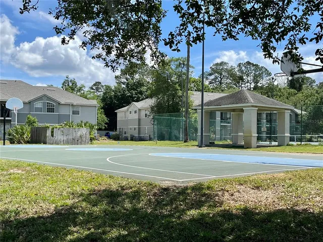 a front view of a house with a yard and large trees