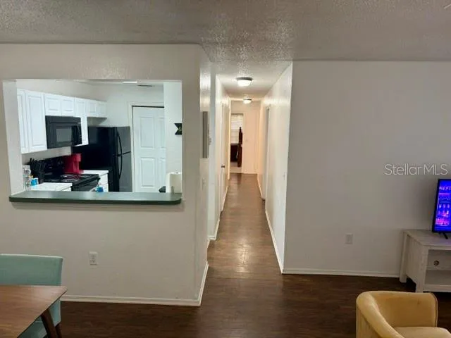 a view of hallway with furniture and wooden floor
