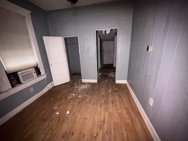 a view of a hallway with wooden floor and staircase