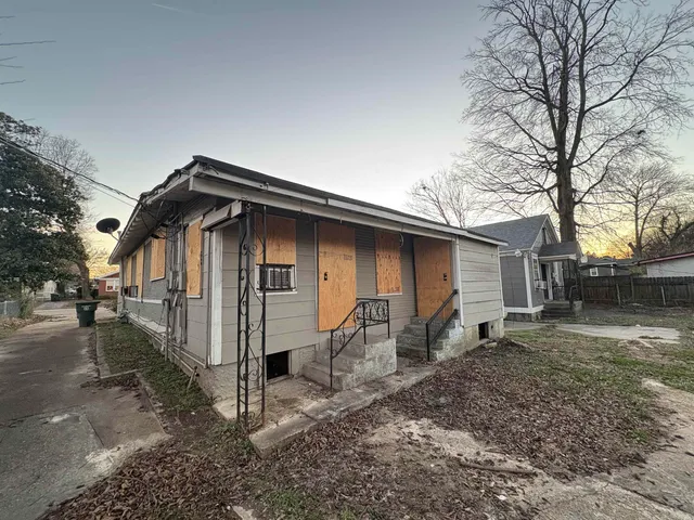 a backyard of a house with barbeque oven and outdoor seating