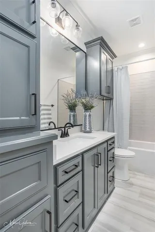 a bathroom with a double vanity sink toilet mirror and bathtub
