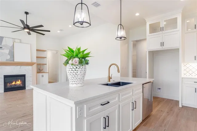 a kitchen with stainless steel appliances granite countertop a sink a stove and a wooden floor