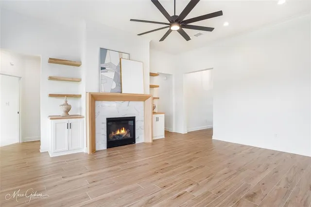 a view of a livingroom with a fireplace and a ceiling fan