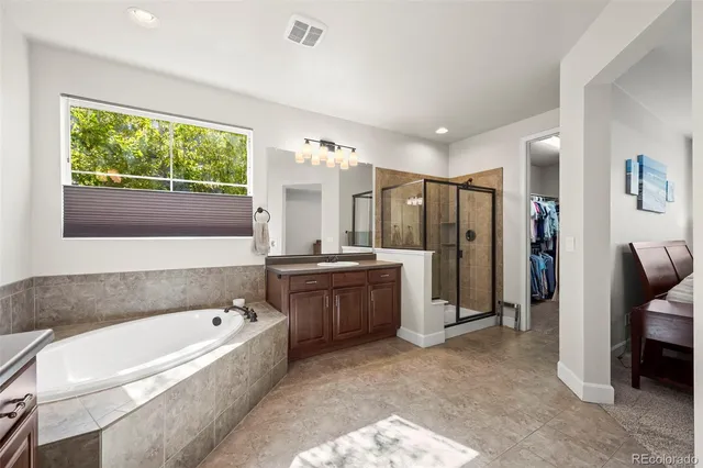 a bathroom with a tub a sink and a large mirror