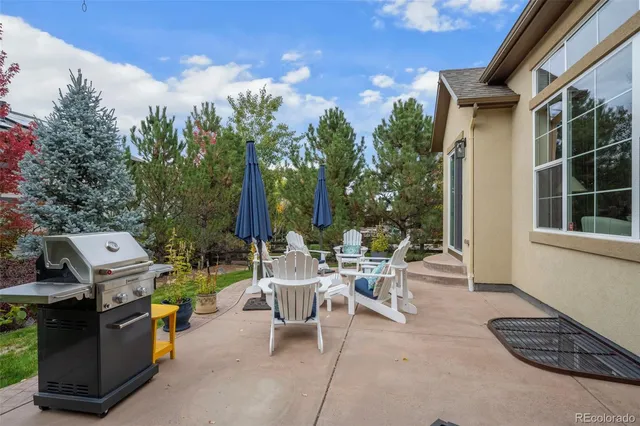 a view of a patio with a table chairs and a backyard