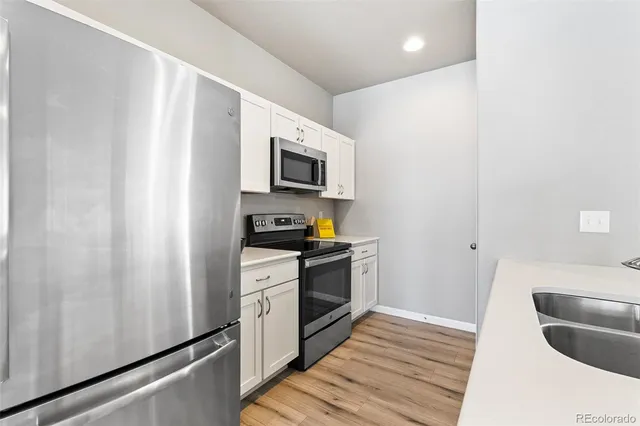 a kitchen with stainless steel appliances a refrigerator sink and microwave